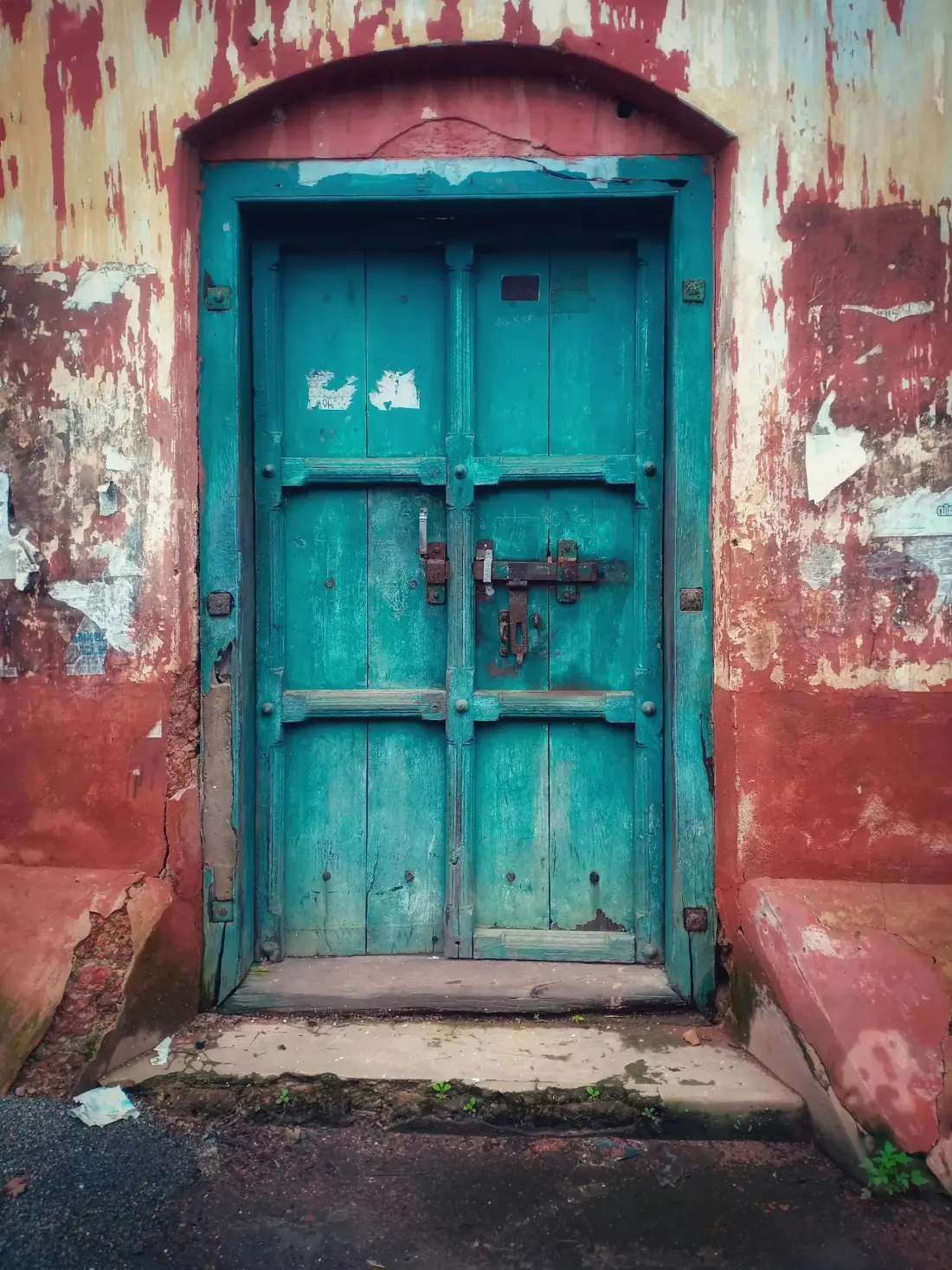 Porte en bois bleu dans un mur ocre de la médina